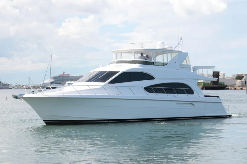  Yacht Photos Pics 2007 Hatteras 64 Motor Yacht cruising on calm waters under a cloudy sky.