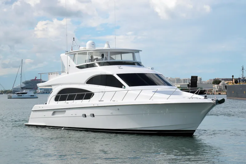  Yacht Photos Pics 2007 Hatteras 64 Motor Yacht cruising in a harbor under a partly cloudy sky.