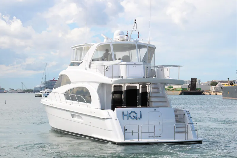  Yacht Photos Pics 2007 Hatteras 64 Motor Yacht cruising in a harbor, rear view.