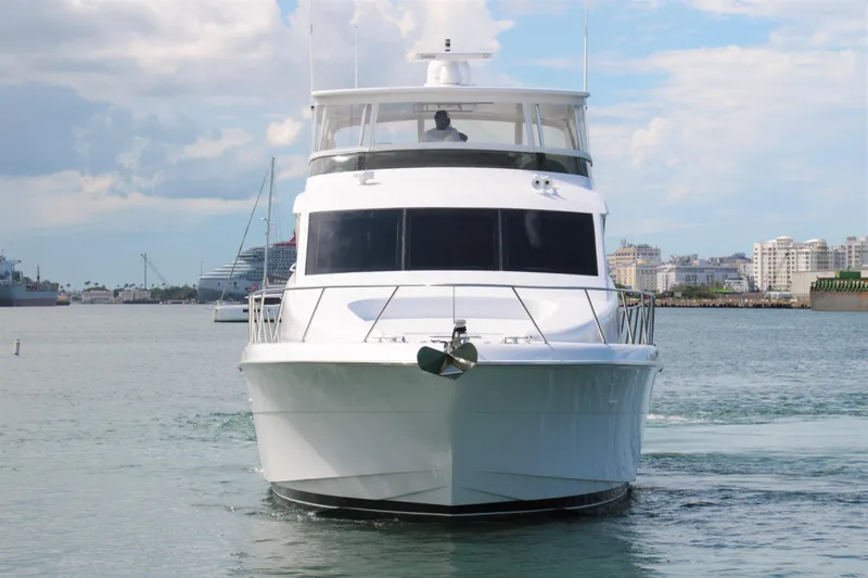  Yacht Photos Pics 2007 Hatteras 64 Motor Yacht cruising in a harbor with cityscape background.