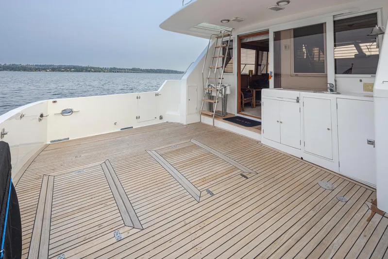 Black Ice Yacht Photos Pics Spacious deck of a 1998 Ocean Alexander 64 yacht with wooden flooring and storage cabinets.