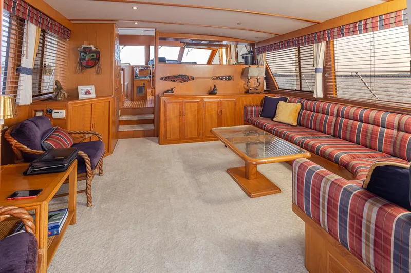 Black Ice Yacht Photos Pics Spacious interior of 1998 Ocean Alexander 64 yacht with striped seating and wooden accents.