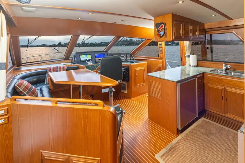 Black Ice Yacht Photos Pics Interior of 1998 Ocean Alexander 64 yacht with helm, dining area, and kitchen.