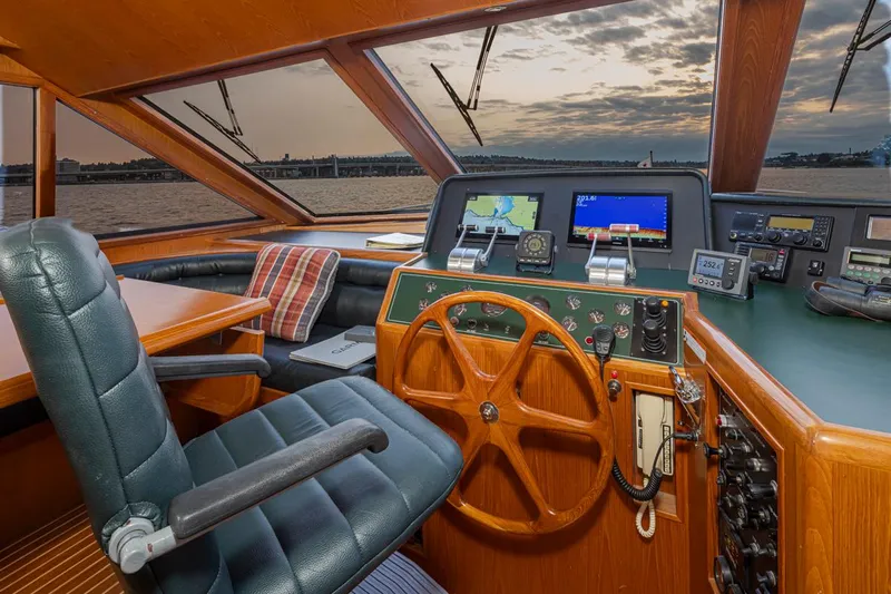 Black Ice Yacht Photos Pics Ocean Alexander 64 yacht helm station, 1998 model, featuring a wooden steering wheel and modern navigation equipment.