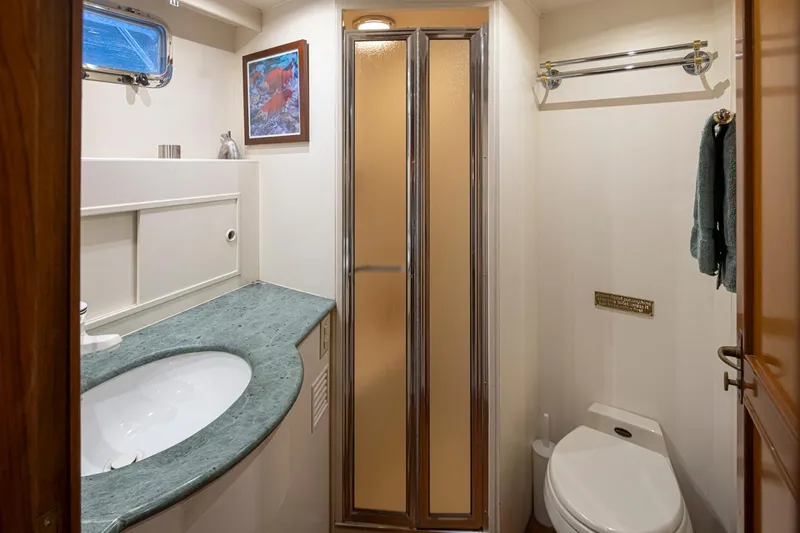 Black Ice Yacht Photos Pics 1998 Ocean Alexander 64 yacht bathroom with shower, sink, and toilet.