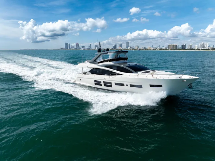 Seaduction Yacht Photos Pics Astondoa 80 GLX yacht cruising on open water, city skyline in background, 2016 model.