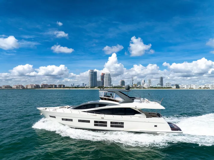 Seaduction Yacht Photos Pics Astondoa 80 GLX 2016 yacht cruising on blue ocean with city skyline backdrop.