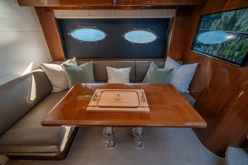 Sea-licious Yacht Photos Pics Luxurious interior of 2016 Princess V48 yacht with elegant seating and wooden table.