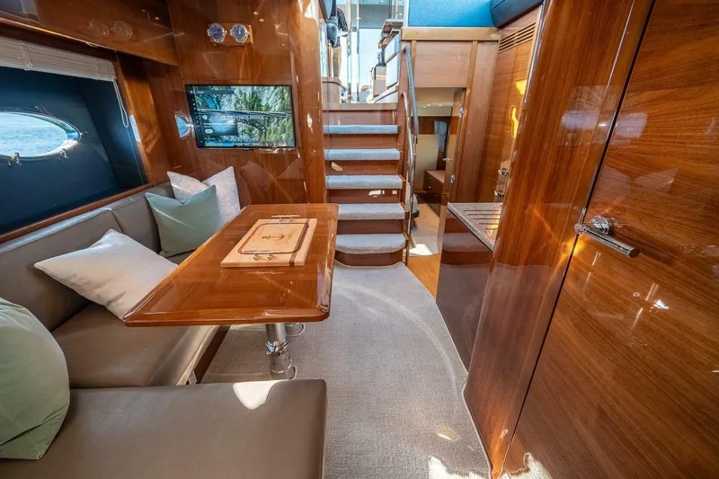 Sea-licious Yacht Photos Pics Luxurious interior of 2016 Princess V48 yacht with elegant wood finishes and cozy seating.