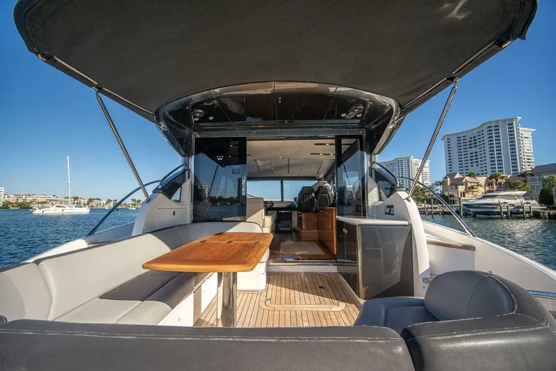 Sea-licious Yacht Photos Pics 2016 Princess V48 yacht interior with seating and table, docked near waterfront buildings.