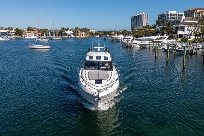 Sea-licious Yacht Photos Pics 2016 Princess V48 yacht cruising in a scenic marina with waterfront homes.