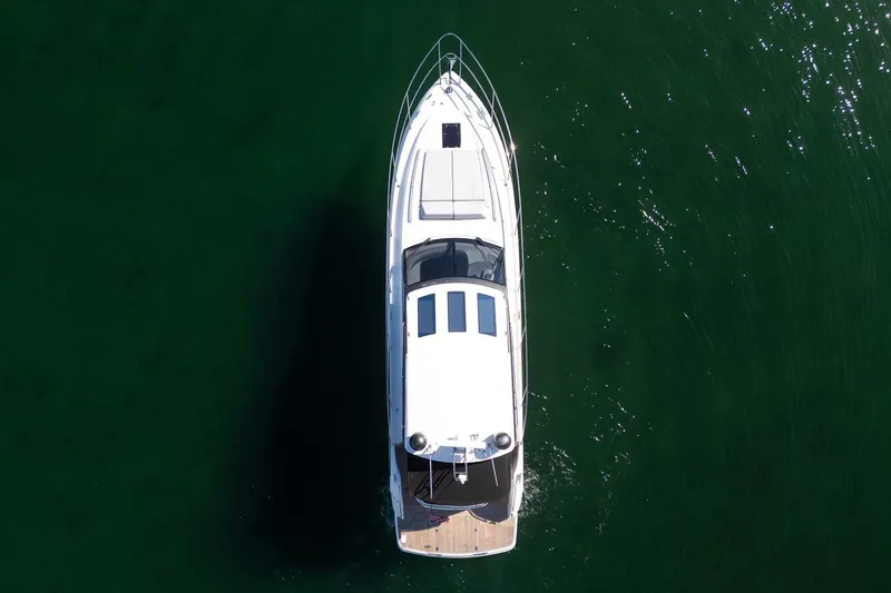 Sea-licious Yacht Photos Pics Aerial view of 2016 Princess V48 yacht cruising on calm green waters.