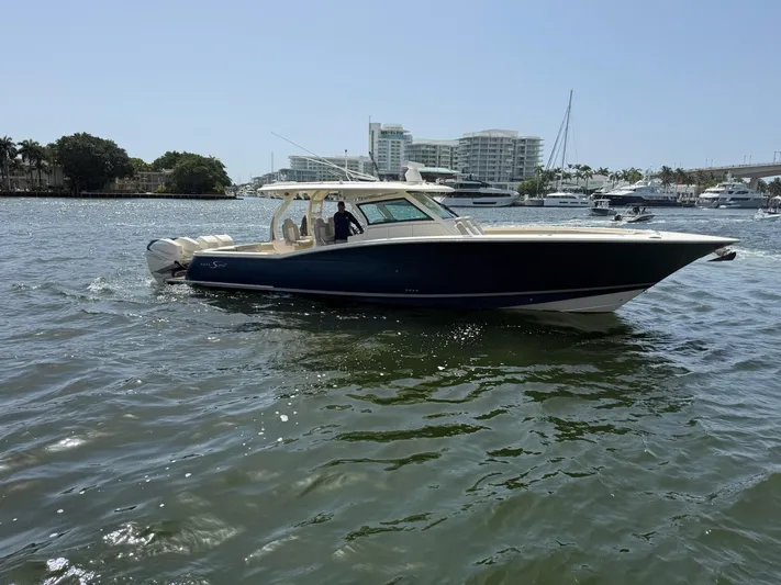 Reel Patience Yacht Photos Pics 2019 Scout 420 LXF boat cruising on a sunny day in a marina.