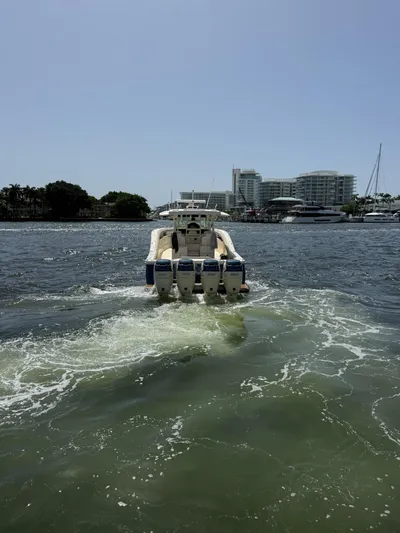 Reel Patience Yacht Photos Pics 2019 Scout 420 LXF boat cruising on a sunny day near waterfront buildings.