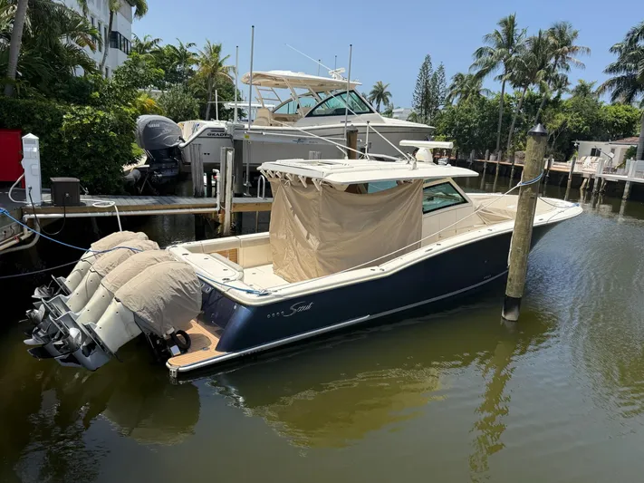 Reel Patience Yacht Photos Pics 2019 Scout 420 LXF boat docked in a tropical marina setting.