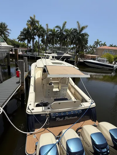 Reel Patience Yacht Photos Pics 2019 Scout 420 LXF boat docked in a scenic marina with palm trees.