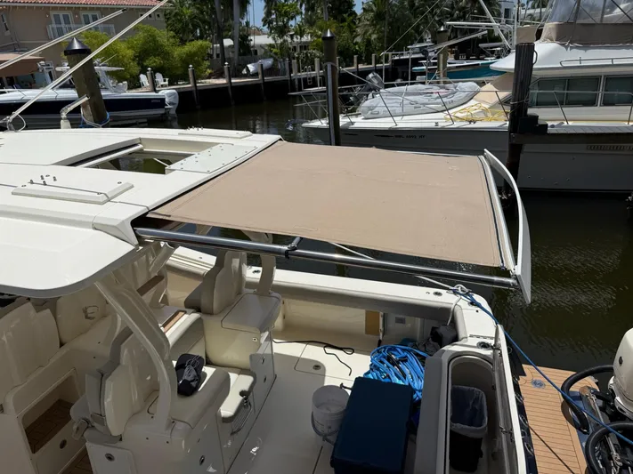 Reel Patience Yacht Photos Pics 2019 Scout 420 LXF boat with sunshade, docked in a marina.