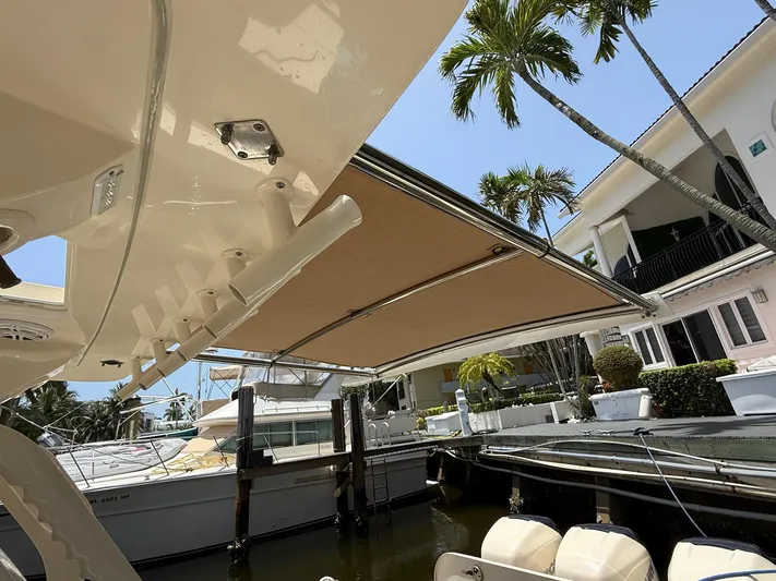 Reel Patience Yacht Photos Pics 2019 Scout 420 LXF boat with canopy, docked near waterfront homes and palm trees.