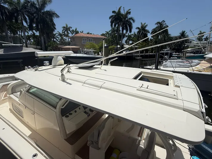 Reel Patience Yacht Photos Pics 2019 Scout 420 LXF boat docked, surrounded by palm trees and other boats.