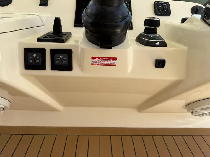 Reel Patience Yacht Photos Pics Control panel of 2019 Scout 420 LXF boat with switches and warning label.