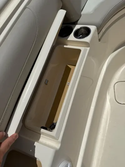 Reel Patience Yacht Photos Pics 2019 Scout 420 LXF boat storage compartment with cup holders and beige interior.