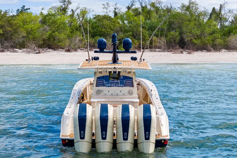 Off Line Yacht Photos Pics 2023 HCB 53 Suenos RXV boat with four engines near a sandy beach.