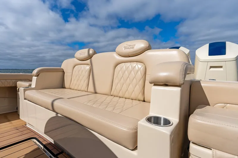 Off Line Yacht Photos Pics Luxurious seating on 2023 HCB 53 Suenos RXV boat under a partly cloudy sky.