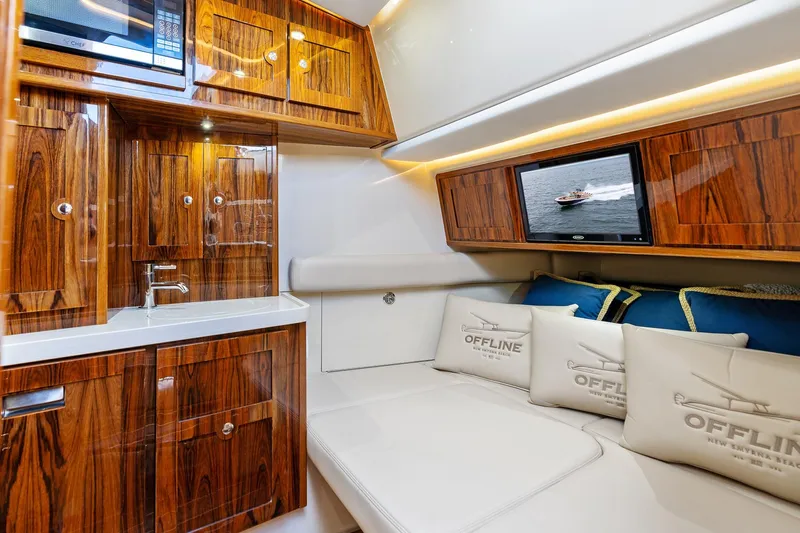 Off Line Yacht Photos Pics Luxurious interior of 2023 HCB 53 Suenos RXV yacht with wood cabinetry and plush seating.