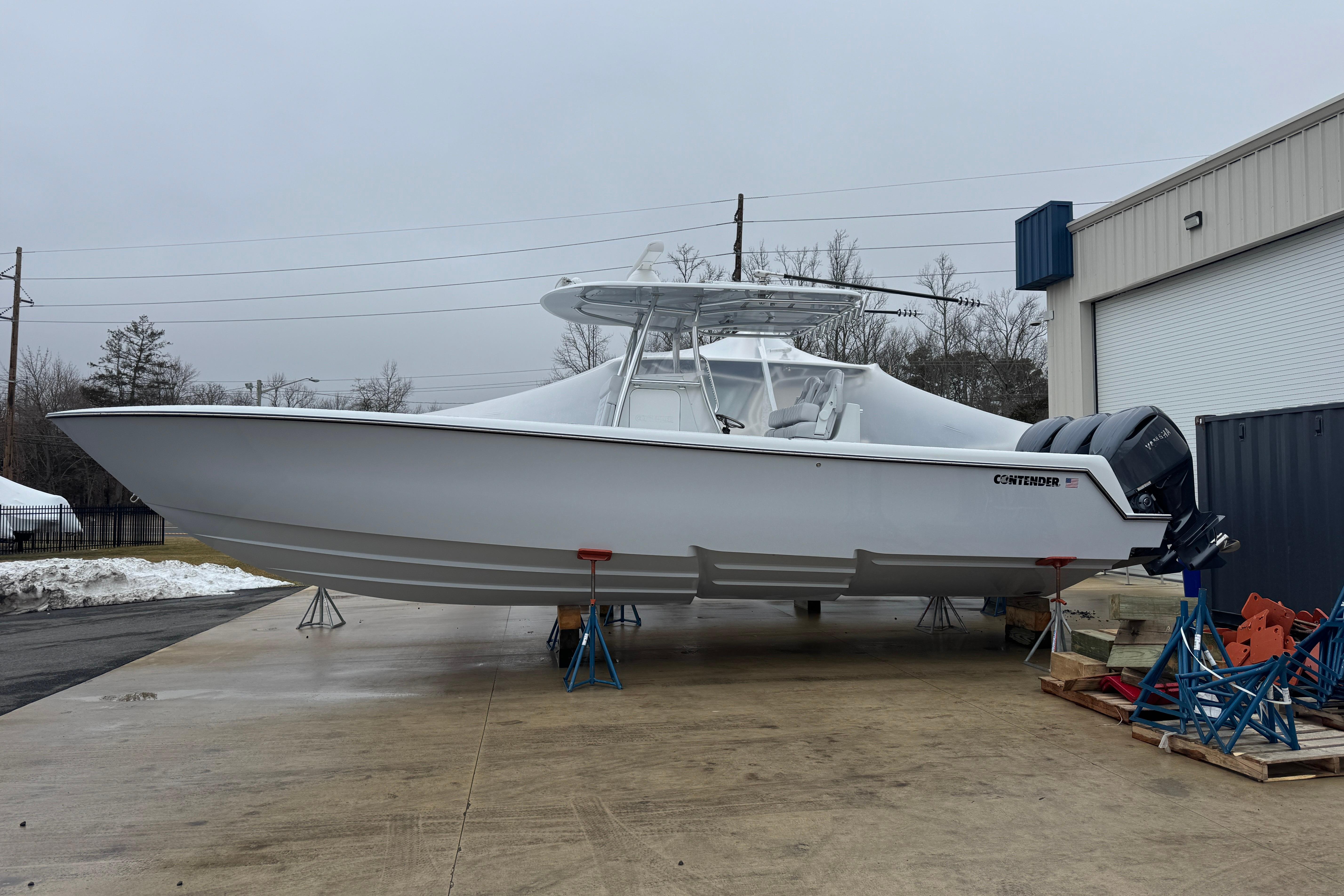2026 Contender 35 ST boat on stands, outdoor storage, overcast sky.