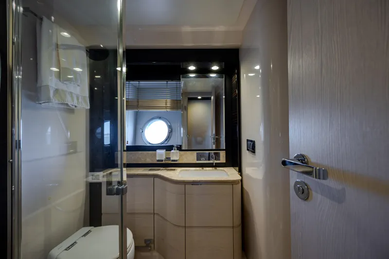  Yacht Photos Pics Luxurious bathroom interior of 2019 Azimut 66 FLY yacht with modern fixtures and porthole window.