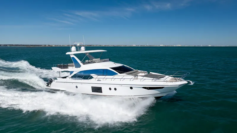  Yacht Photos Pics Luxurious 2019 Azimut 66 FLY yacht cruising on open water under clear blue skies.
