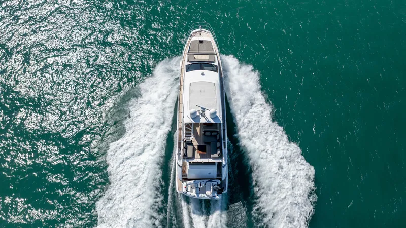  Yacht Photos Pics Aerial view of 2019 Azimut 66 FLY yacht cruising on turquoise water.