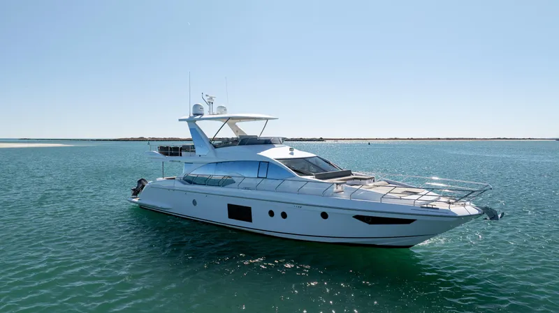  Yacht Photos Pics 2019 Azimut 66 FLY yacht cruising on clear blue waters under a sunny sky.