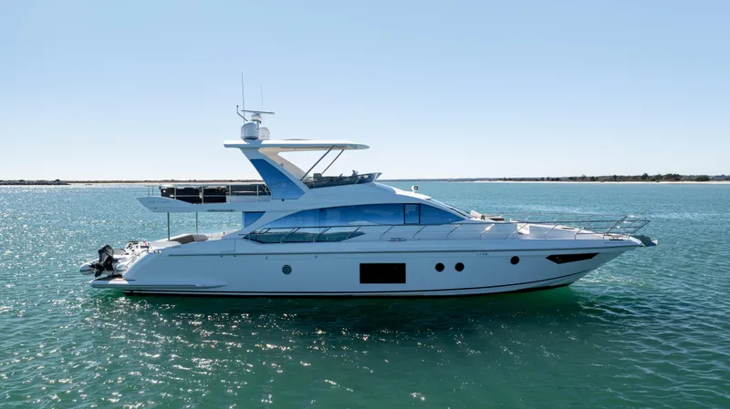 Yacht Photos Pics 2019 Azimut 66 FLY yacht on calm blue water, side view.