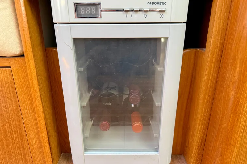 Nereid Yacht Photos Pics Wine cooler in a 2020 Catalina 425 yacht interior, featuring wooden cabinetry.