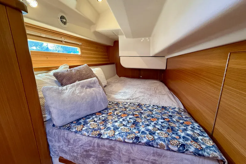 Nereid Yacht Photos Pics Cozy cabin interior of 2020 Catalina 425 yacht with comfortable bedding and wooden accents.