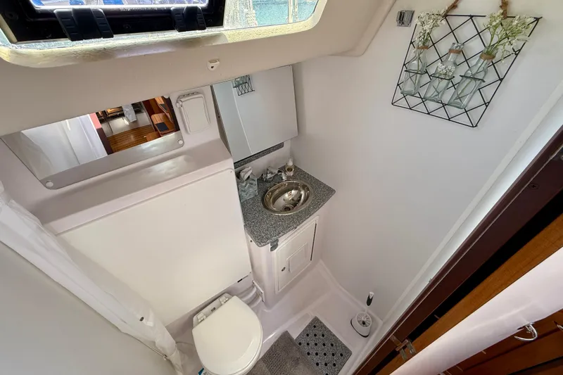 Nereid Yacht Photos Pics Compact bathroom in 2020 Catalina 425 yacht with sink, toilet, and decorative wall art.