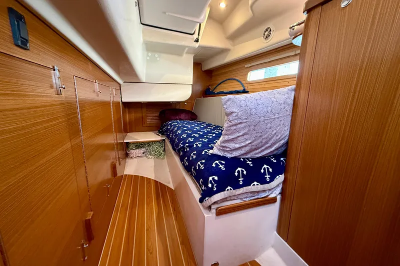 Nereid Yacht Photos Pics Cozy cabin interior of 2020 Catalina 425 sailboat with wooden finish and nautical bedding.