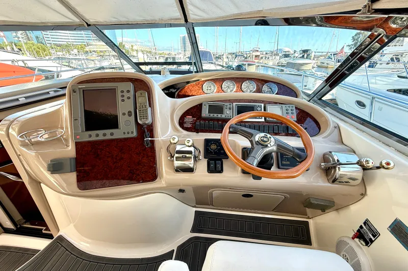 The Office Yacht Photos Pics Helm of 2003 Sea Ray 380 Sundancer with wood accents and modern navigation equipment.