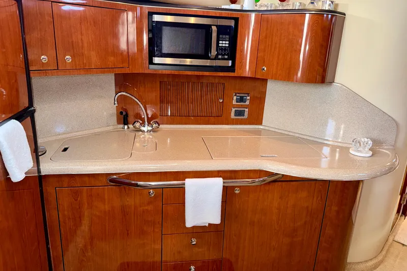 The Office Yacht Photos Pics 2003 Sea Ray 380 Sundancer galley with wood cabinetry, sink, and microwave.