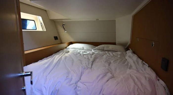 Yagiza Yacht Photos Pics Cozy cabin interior of 2020 Beneteau First 53 yacht with a neatly made bed.