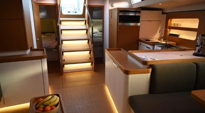 Yagiza Yacht Photos Pics Luxurious interior of 2020 Beneteau First 53 yacht with modern kitchen and cozy seating area.