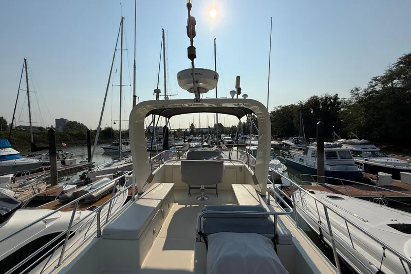 Raven Song Yacht Photos Pics 2011 North Pacific 38 Sedan yacht docked in a marina under clear skies.