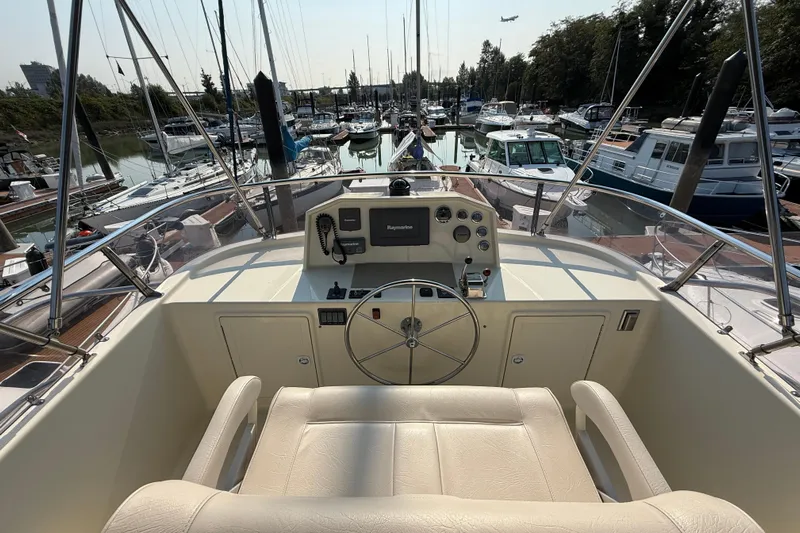 Raven Song Yacht Photos Pics 2011 North Pacific 38 Sedan yacht helm with marina view, featuring steering wheel and controls.