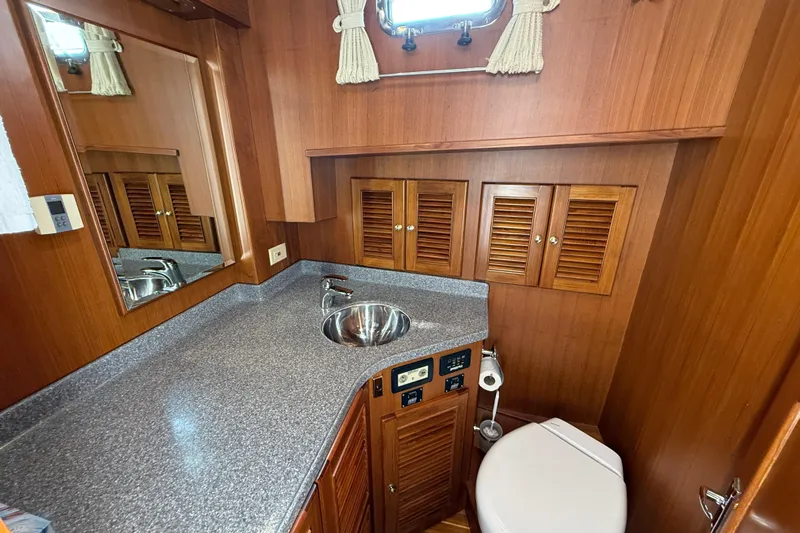 Raven Song Yacht Photos Pics 2011 North Pacific 38 Sedan bathroom with wood cabinetry, sink, and toilet.