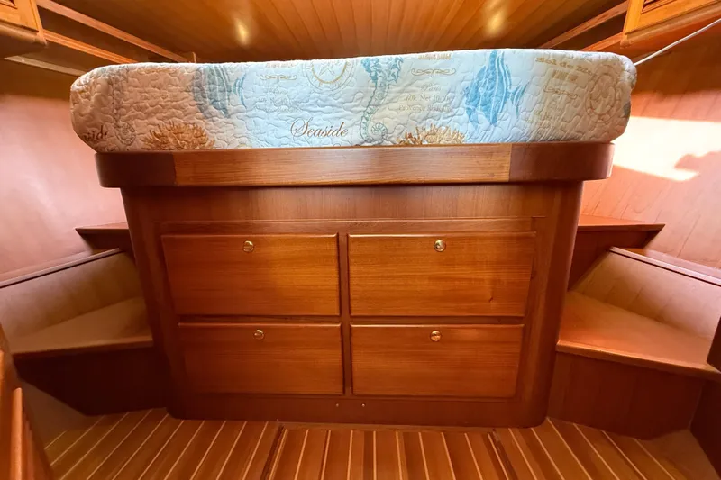Raven Song Yacht Photos Pics 2011 North Pacific 38 Sedan interior with wooden cabinetry and nautical-themed bedding.