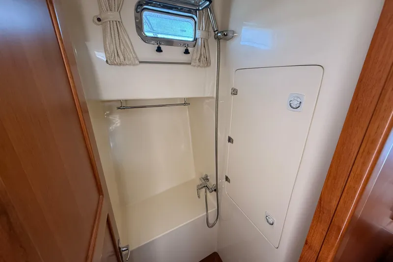 Raven Song Yacht Photos Pics Shower area in 2011 North Pacific 38 Sedan boat with window and curtain.