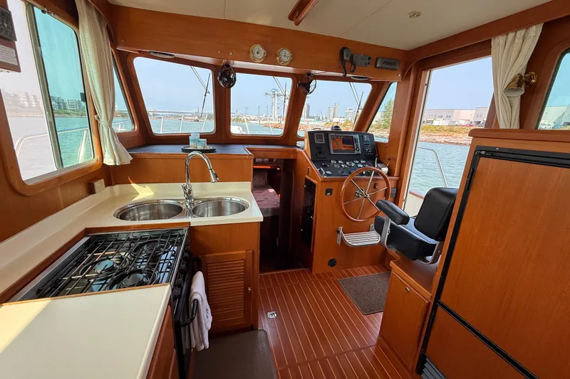 Raven Song Yacht Photos Pics 2011 North Pacific 38 Sedan interior with kitchen, steering wheel, and navigation equipment.