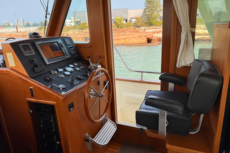Raven Song Yacht Photos Pics Interior helm of 2011 North Pacific 38 Sedan with navigation controls and captain's chair.