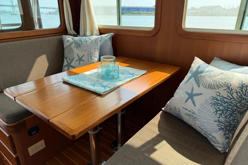 Raven Song Yacht Photos Pics Cozy dining area in 2011 North Pacific 38 Sedan with nautical-themed decor.